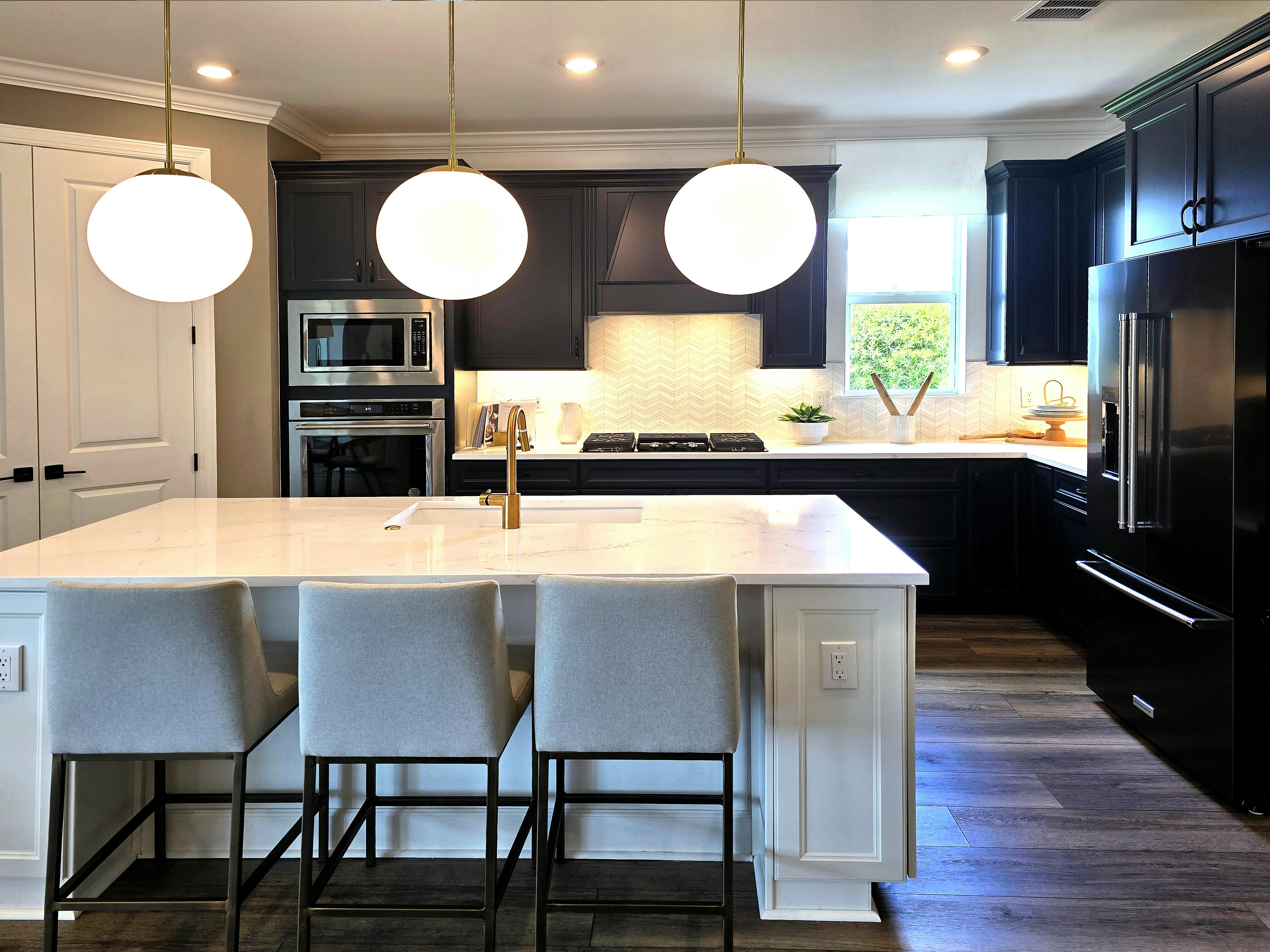 Sleek kitchen design featuring an island, pendant lights, and contemporary appliances. Kitchen remodel project